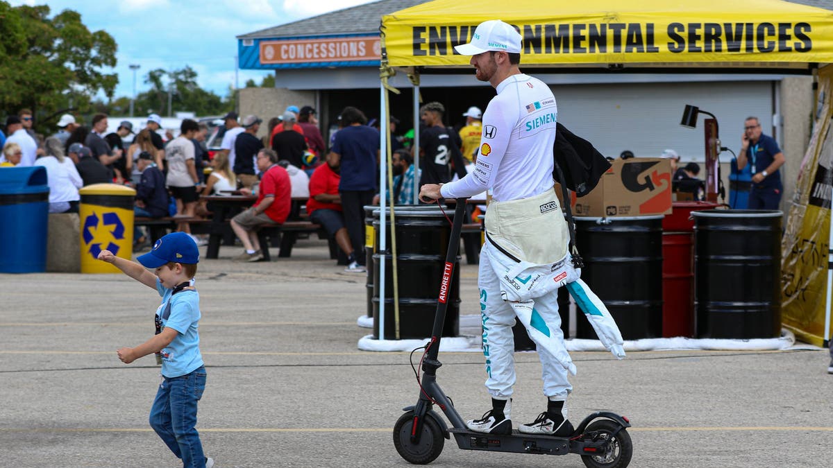 Then it's off to the track as Kirkwood navigates his scooter around a young fan leading the way. (Photo by Ed McGregor/FOX Sports)