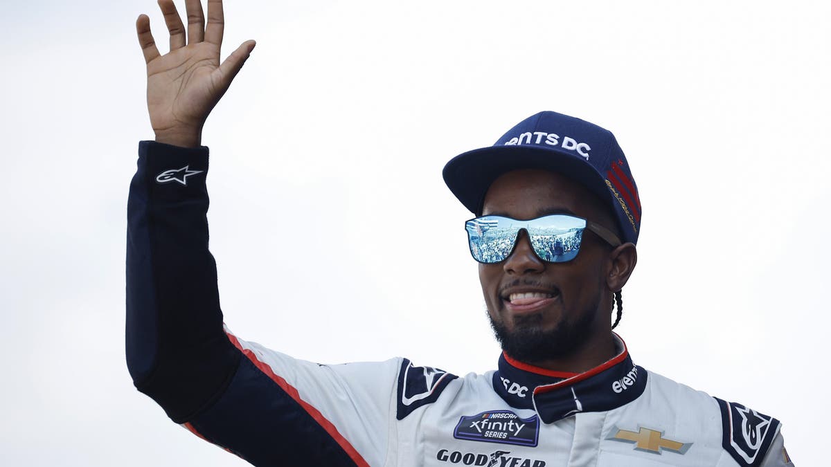 Rajah Caruth waves to fans as he walks onstage during driver intros prior to the NASCAR Xfinity Series BetRivers 200 at Dover Motor Speedway