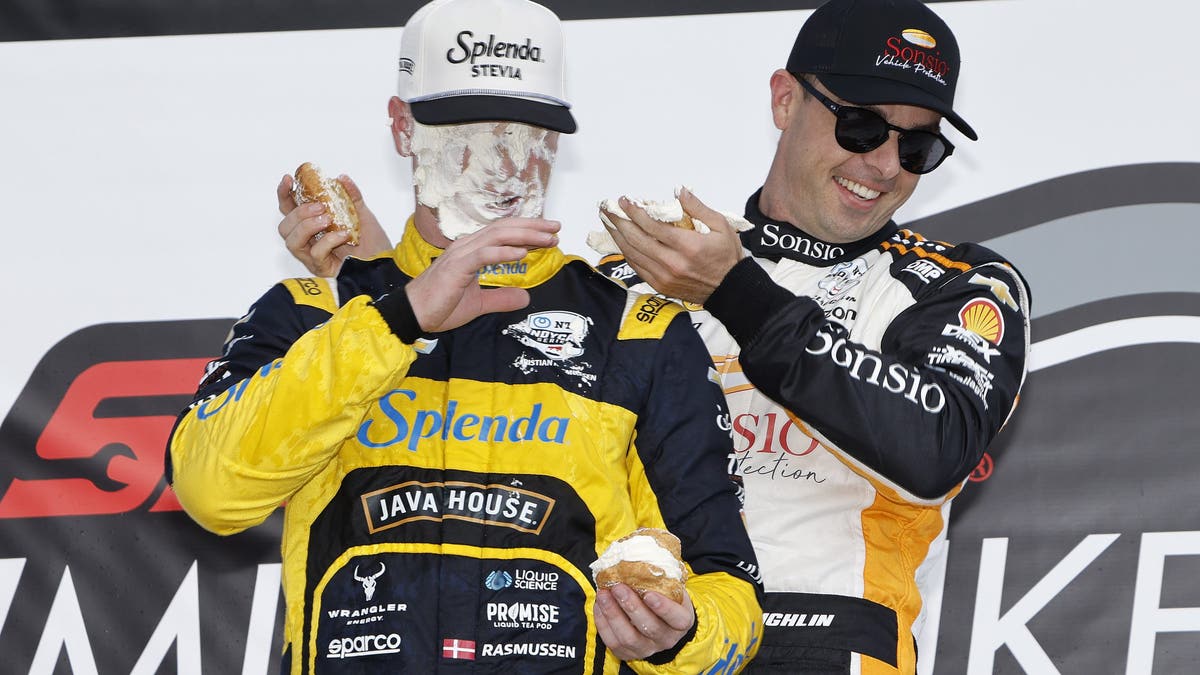 Christian Rasmussen gets a creampuff in his face from Scott McLaughlin on the podium during the INDYCAR Series Snap-On Milwaukee Mile 250.