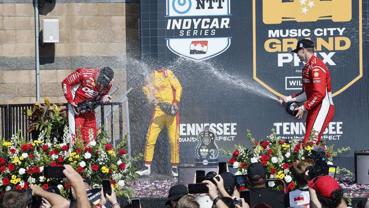 Josef Newgarden (center) celebrates on the podium with Scott McLaughlin and Alex Palou after winning Nashville 