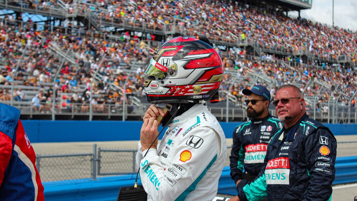 As crew chief Scott Marks looks on, Kirkwood straps on his helmet before climbing into the car. (Photo by Ed McGregor/FOX Sports)