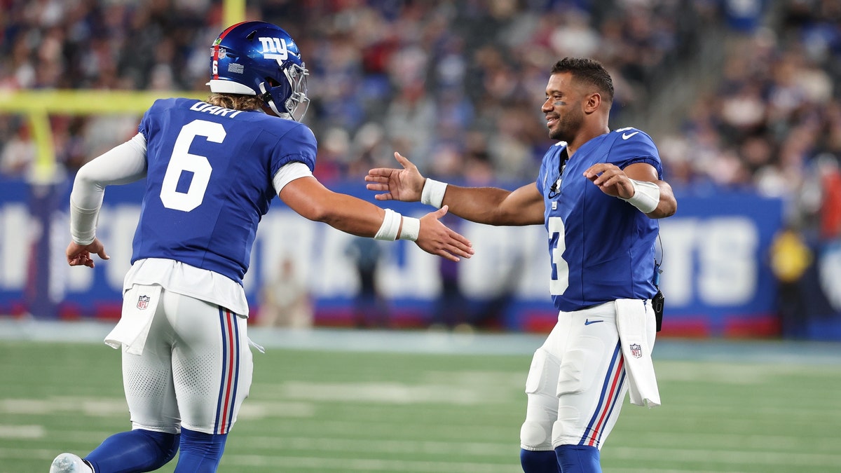 Jaxson Dart (left) is the Giants' future at quarterback, but Russell Wilson will open the season as the starter. (Al Bello/Getty Images)