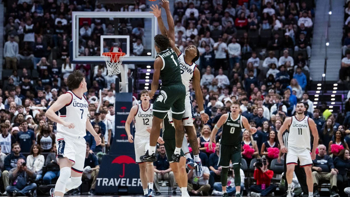 Jeremy Fears Jr. #1 of the Michigan State Spartans and Silas Demary Jr. #2 of the Connecticut Huskies go for the loose ball during the second half of an NCAA men's basketball exhibition. (Photo by Joe Buglewicz/Getty Images)