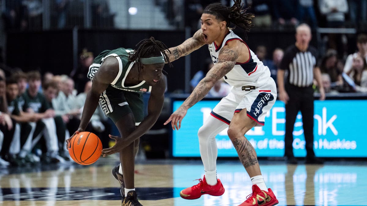 Solo Ball #1 of the Connecticut Huskies reacts while defending Kur Teng #2 of the Michigan State Spartans during the second half of an NCAA men's basketball exhibition. (Photo by Joe Buglewicz/Getty Images)