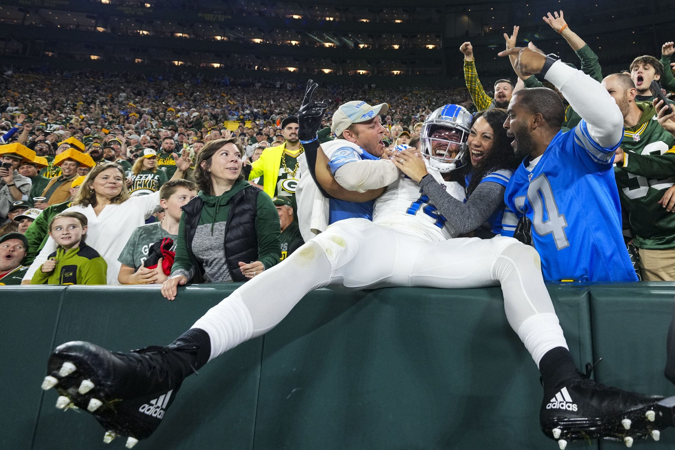 Not many players on the visiting team dare to try the Lambeau Leap, like Amon-Ra St. Brown. (Photo by Cooper Neill/Getty Images)