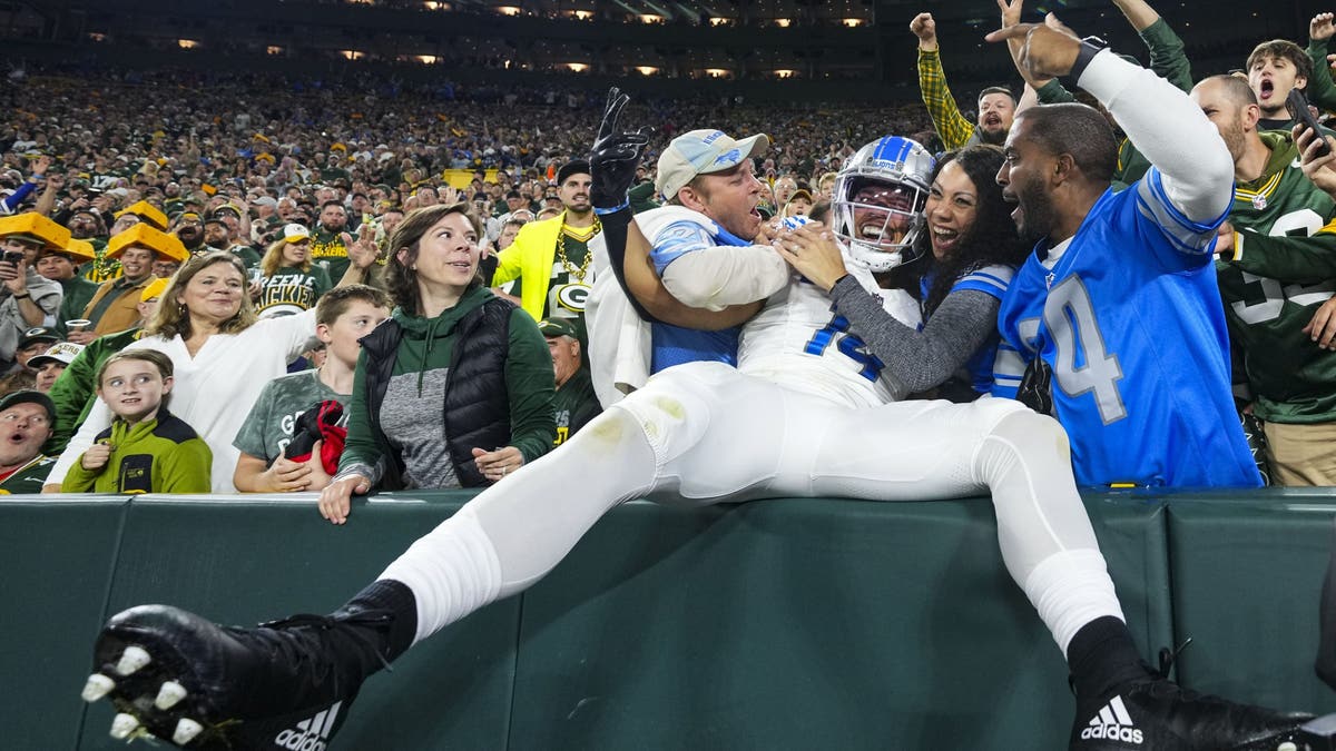 Not many players on the visiting team dare to try the Lambeau Leap, like Amon-Ra St. Brown. (Photo by Cooper Neill/Getty Images)