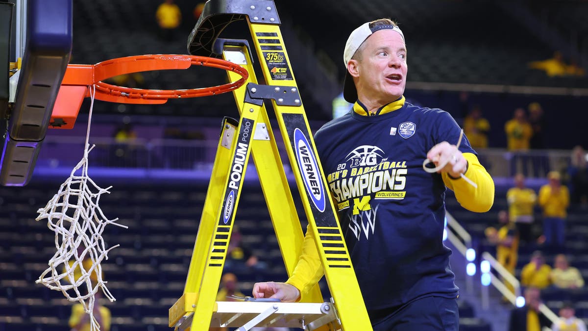 Michigan head coach Dusty May cuts down a net after winning the Big Ten regular-season title. (Photo by Gregory Shamus/Getty Images)