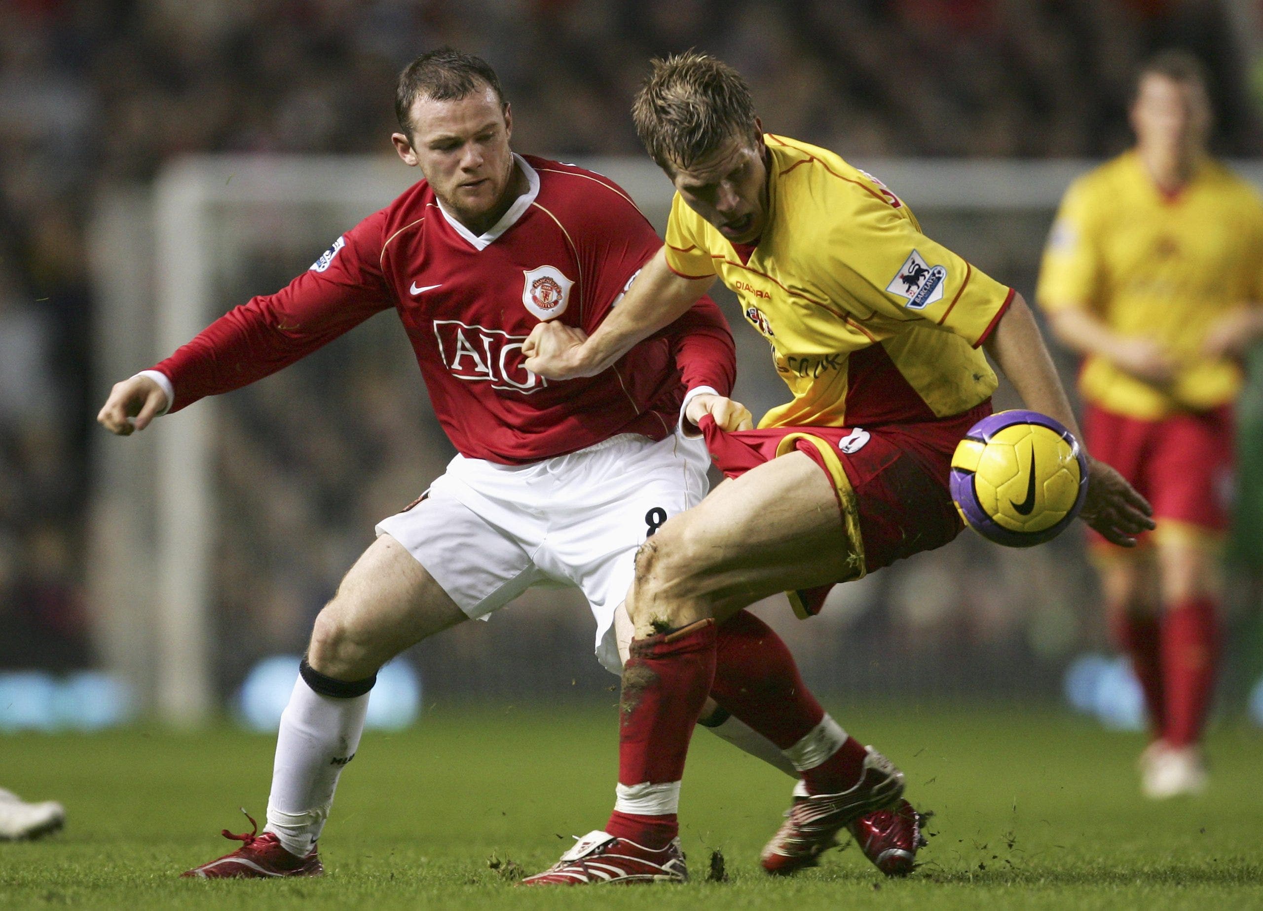Jay Demerit holds off a challenge from Wayne Rooney. (Richard Heathcote/Getty Images)